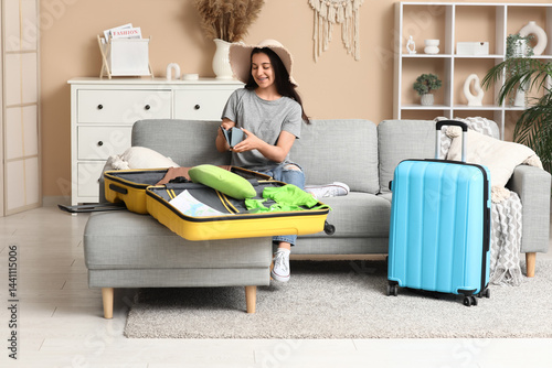 Young woman packing clothes...