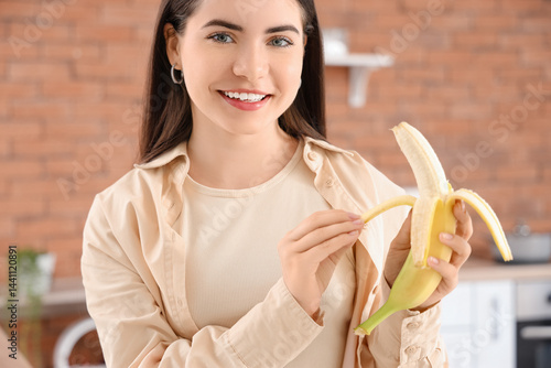 Young woman peeling banana ...