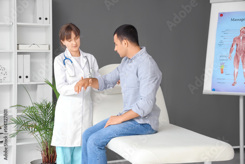 Female doctor examining man...