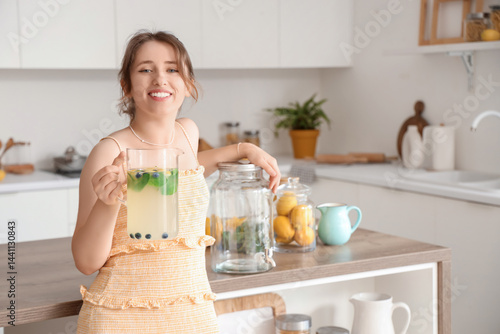 Young woman with jug of tas...