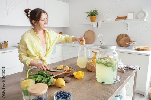Young woman making lemonade...