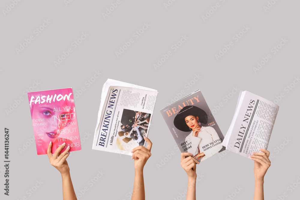 Female hands with different magazines and newspapers on grey background
