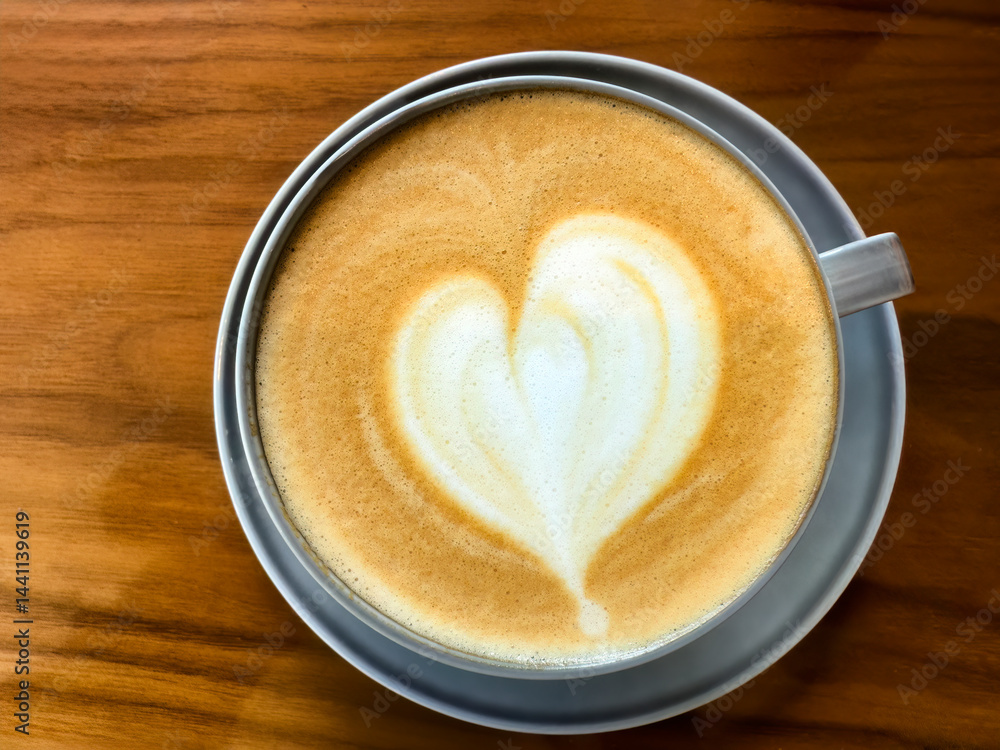 Overhead view of creamy coffee with love heart shape on top
