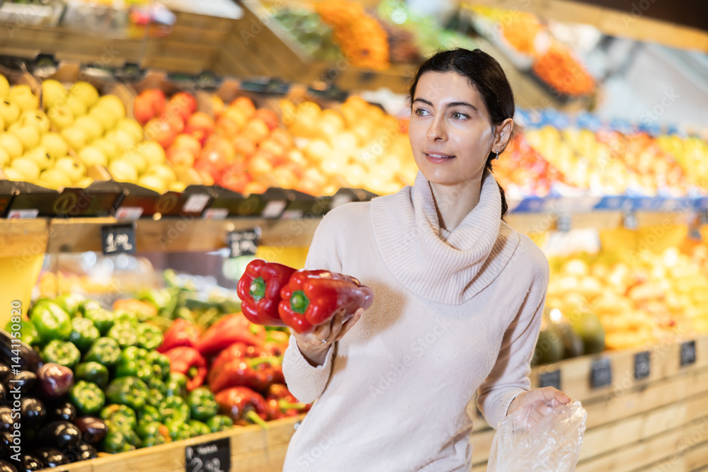 While shopping in vegetable store, female customer purchase fresh bell pepper. Wide range of agricultural products. Self-service, comfortable shopping. While shopping in vegetable store, female customer purchase fresh bell pepper. Wide range of agricultural products. Self-service, comfortable shopping.