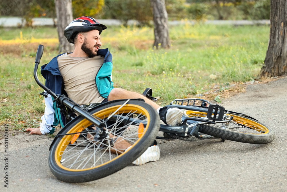 Young man fallen off his bike outdoors