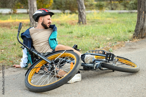 Young man fallen off his bike outdoors
