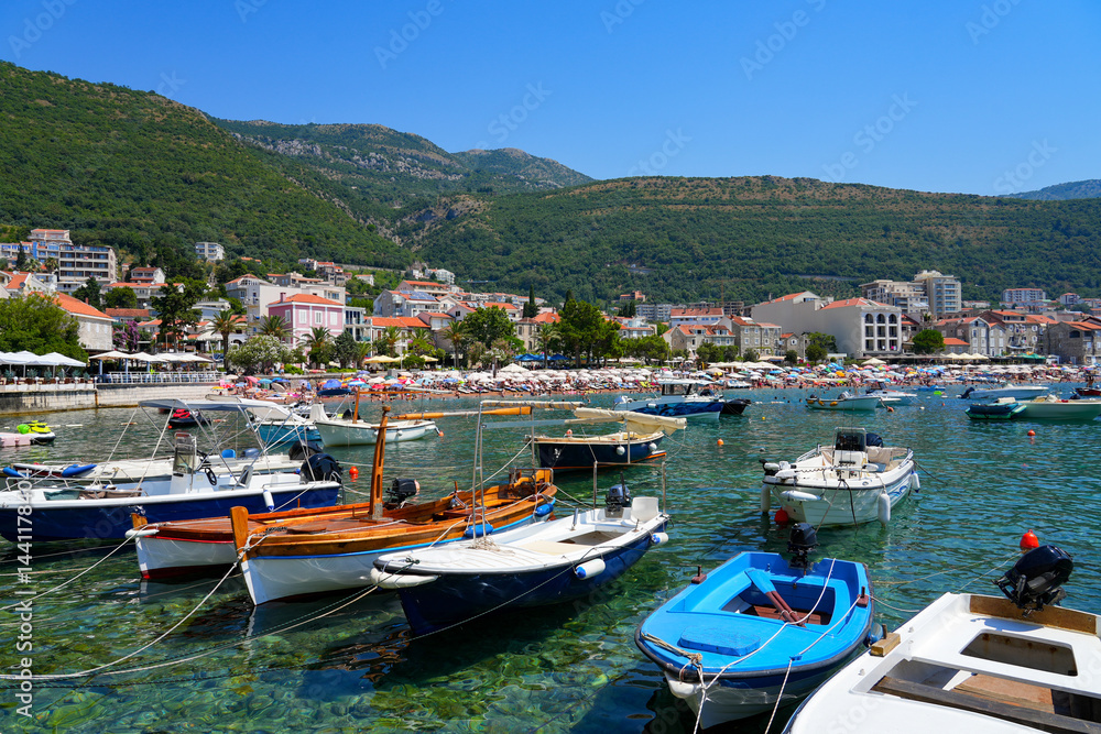 Fishing boats moored in front of the beach of Petrovac na Moru, a resort town located on the coast of the Adriatic Sea in Montenegro