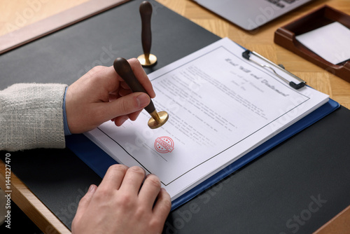 Cuadro en lienzo Man stamping document with Licensed stamp at table, closeup
