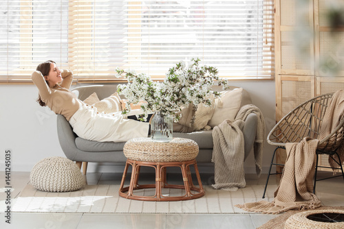Young woman lying on sofa w...