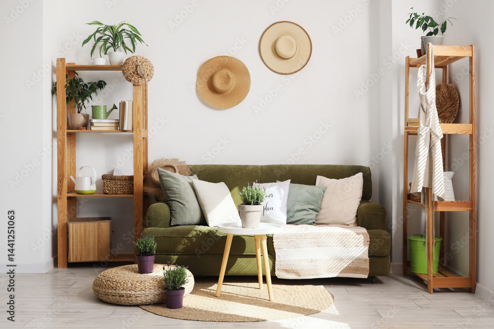 Interior of living room with green sofa, shelf units and lavender flowers