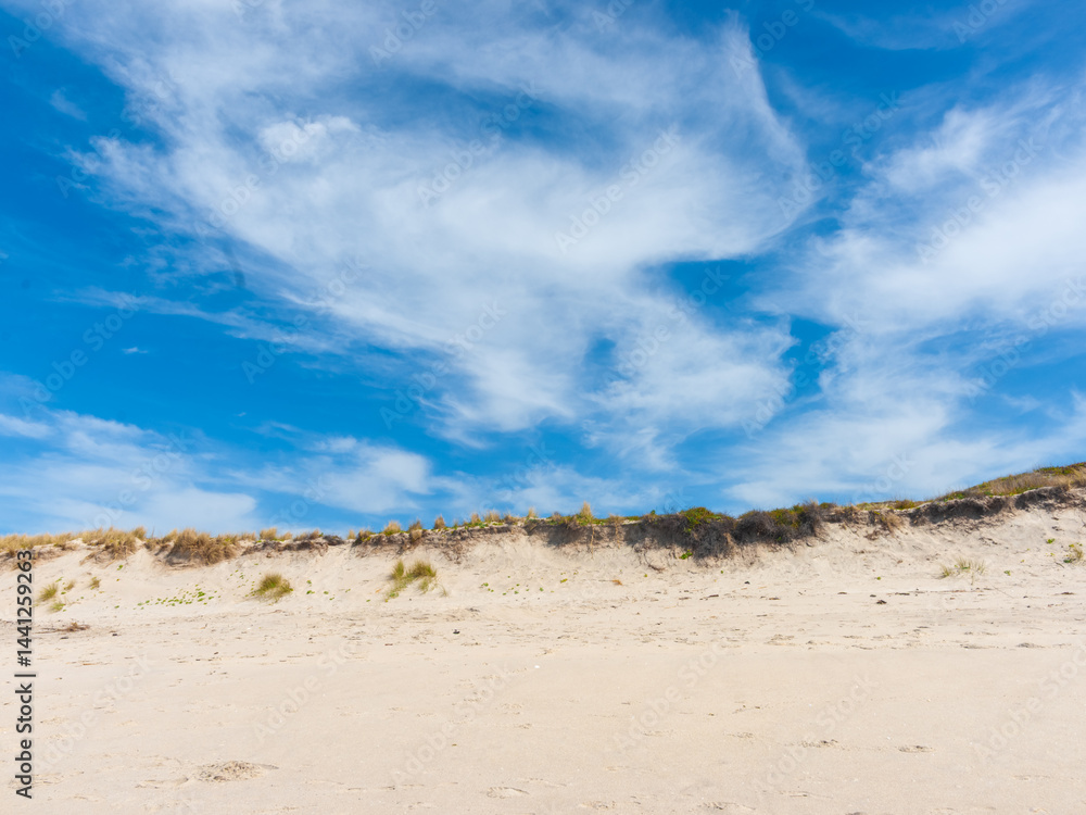 Cloud formation in sky above beach sand dune at Papamoa New Zealand.