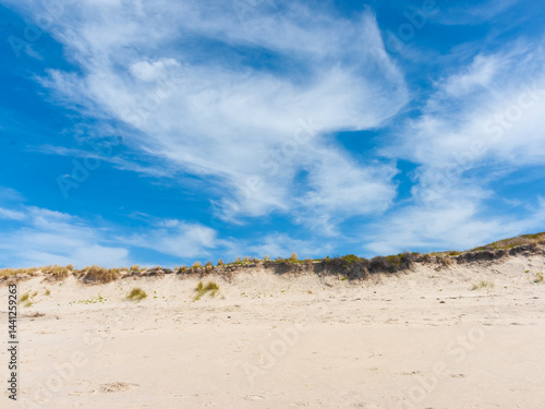 Cloud formation in sky above beach sand dune at Papamoa New Zealand.
