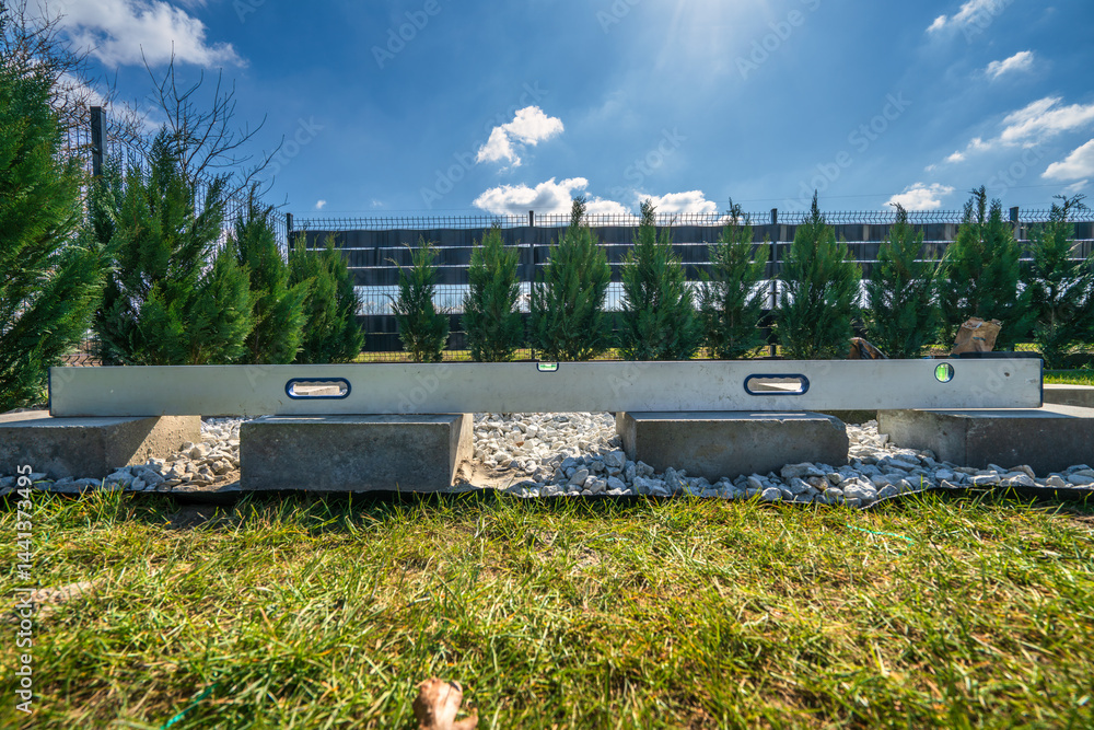 Spirit level on top of concrete blocks. Preparation for garden shed foundation