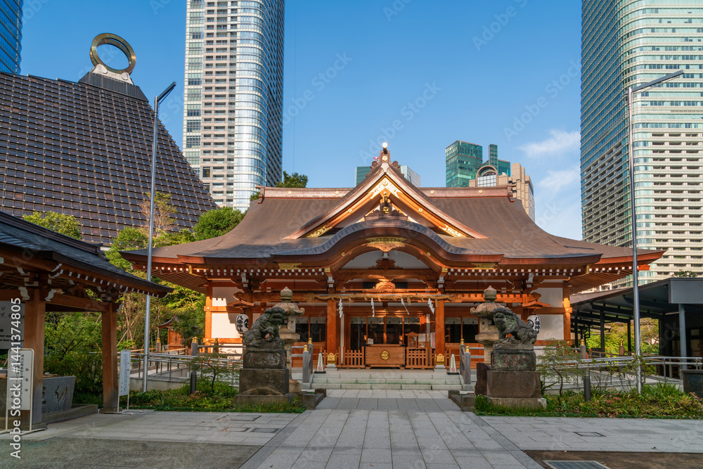View of the Nishikubo Hachiman Shrine in the background of the complex Azabudai Hills in the Toranomon business district, in the ward of Minato on a sunny autumn day, Tokyo, Japan