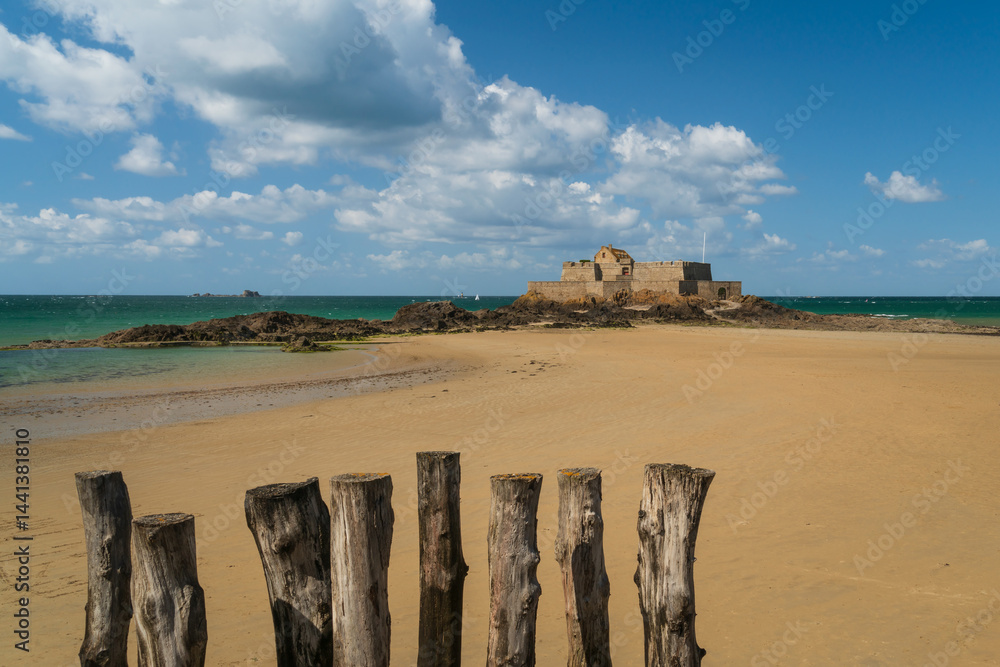 View of the Petit Be Fort on a small island and the exposed ocean floor at low tide on a sunny summer day, Saint-Malo, Brittany, France