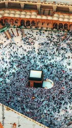 Dynamic hyperlapse capturing a detailed aerial view of pilgrims circling the Kaaba at the Grand Mosque in Mecca, Saudi Arabia during pilgrimage