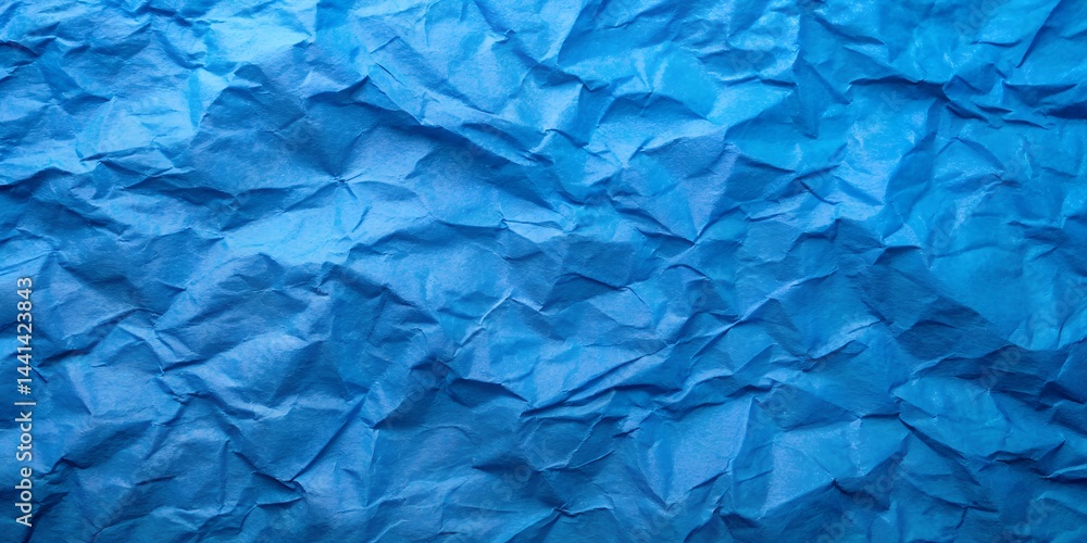 Fototapeta premium A blank, rough sheet of crumpled blue paper shows a wrinkled texture and creased pattern