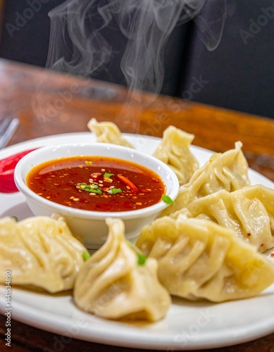 a steaming plate of momos with chili sauce for a spicy, soul-warming bite