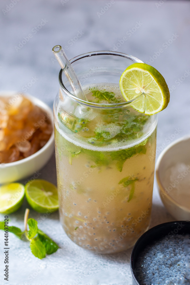 Fototapeta premium Gond katira drink with sabja seeds, mint, and lemon juice is a cooling, hydrating beverage, combining herbal flavors, citrus tang, and natural energy-boosting properties, perfect for summer.
