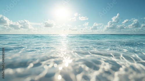 Obraz na płótnie Bright sun shines over a calm, clear ocean with gentle waves and scattered clouds in a serene blue sky. w salonie