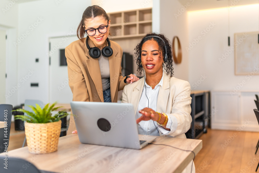 Businesswomen working together on laptop in office