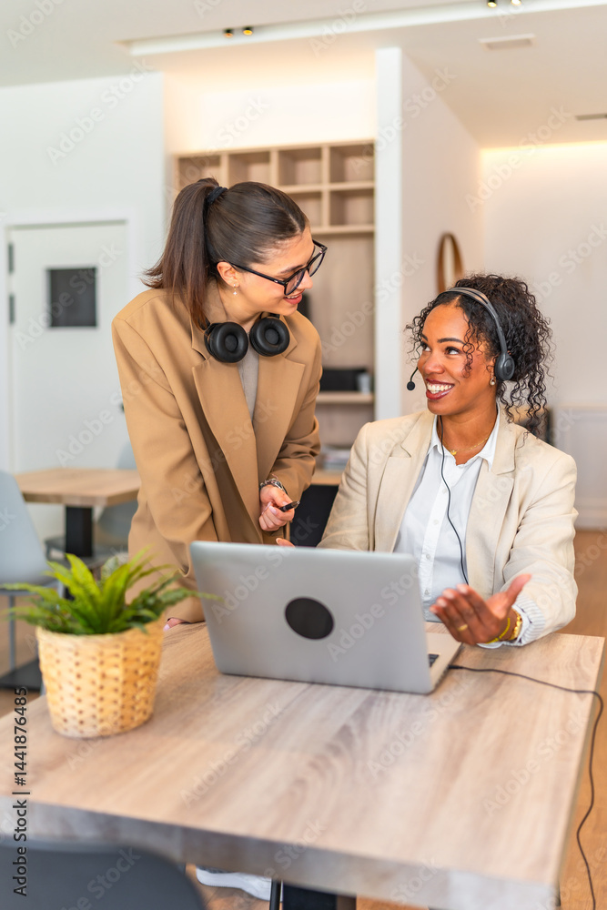 Businesswomen working together on laptop in modern office