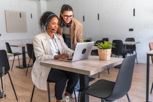 Obraz na płótnie Businesswomen working together on laptop in modern office w salonie