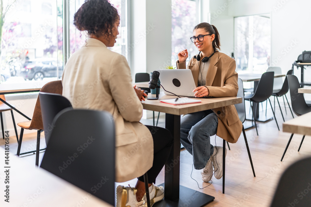 Two content creators recording a podcast in a modern cafe