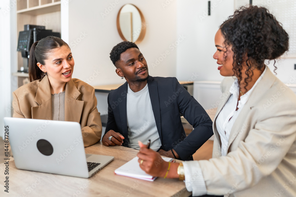 Business team discussing strategy during meeting with laptop in modern office