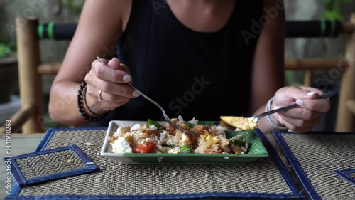 Person savoring nasi goreng at local restaurant
