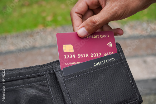 Man takes credit card out of wallet. Take out a credit card to pay.