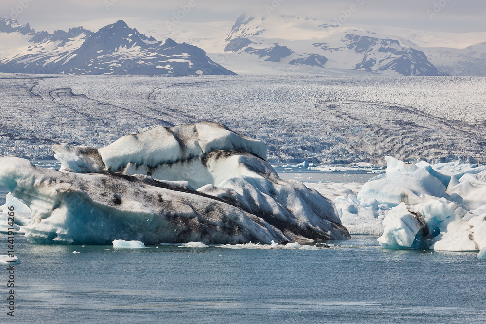 Icebergs turquoise lake and snowy mountains. Jokulsarlon, Southeast area. Iceland.
