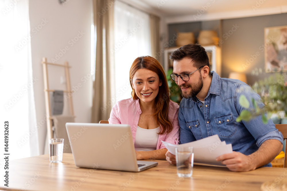 A smiling couple collaborates on financial planning at home, using a laptop and discussing important documents. Their teamwork and organization reflect a positive and balanced lifestyle. A smiling couple collaborates on financial planning at home, using a laptop and discussing important documents. Their teamwork and organization reflect a positive and balanced lifestyle.