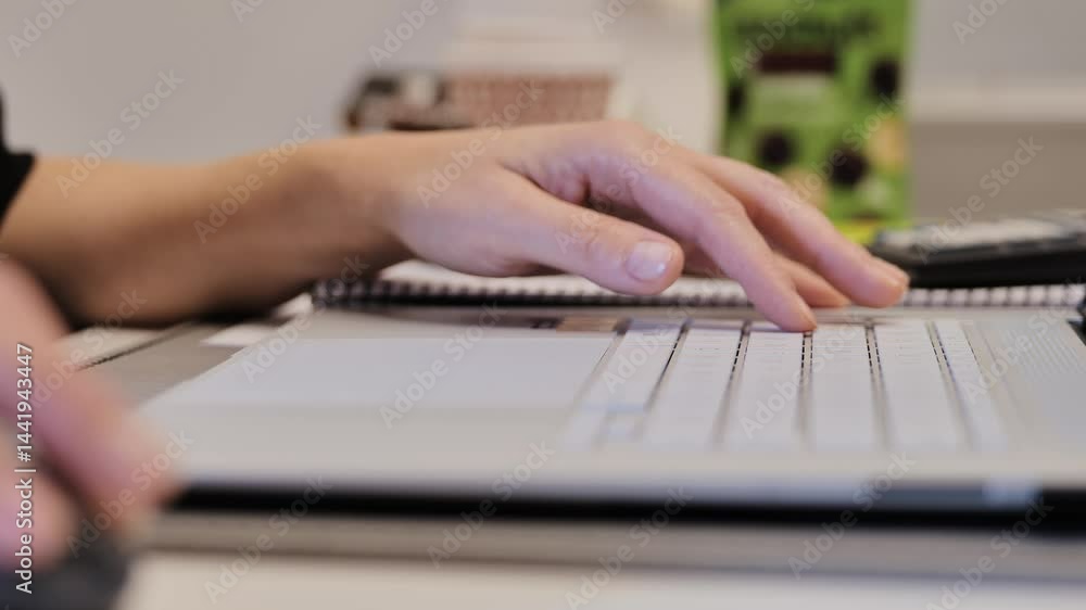 Focused woman working on laptop using wireless mouse in bright modern workspace Focused woman working on laptop using wireless mouse in bright modern workspace