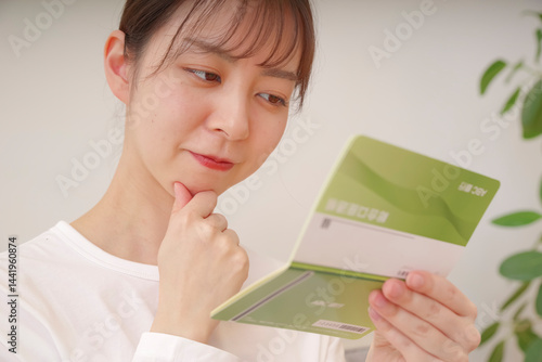 通帳を見て複雑な表情をする女性