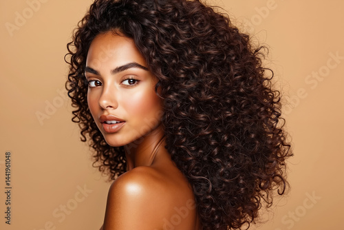 A woman with long curly hair is posing for a picture