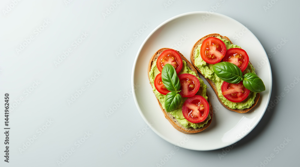 A minimalist flat-lay of avocado toast topped with fresh tomato slices and basil leaves, placed on a clean white plate. The background is a smooth, light gray, making the colors of the toast pop. A minimalist flat-lay of avocado toast topped with fresh tomato slices and basil leaves, placed on a clean white plate. The background is a smooth, light gray, making the colors of the toast pop.