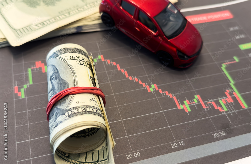 graphics down on the background of the car and money cash dollars. Concept of falling car market, insurance, lower prices, repair costs
