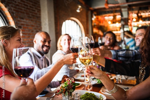 Fotografía Group of people toasting with wine glasses at a lively dinner gathering