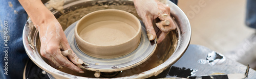 Canvas Print Hands sculpting a beautiful bowl in a vibrant pottery studio full of creative en