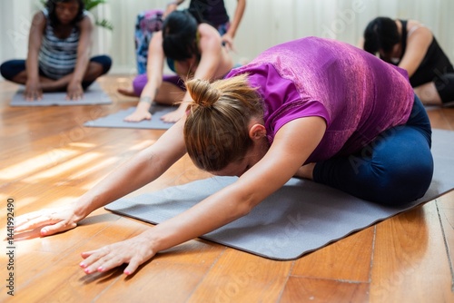 Group yoga class with diverse women practicing yoga poses on mats. Yoga for relaxation, yoga for flexibility, yoga for wellness. Peaceful yoga session. Women pregnancy, yoga exercise concept.