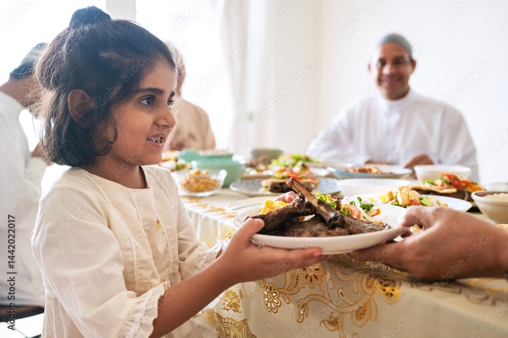 A joyful young girl, of Middle Eastern descent, serves a delicious meal at a family gathering, showcasing a rich cultural dining experience of Middle Eastern family. A joyful young girl, of Middle Eastern descent, serves a delicious meal at a family gathering, showcasing a rich cultural dining experience of Middle Eastern family.