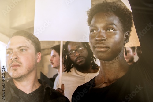 Diverse group of people holding protest signs. Group of various ethnicity people united in protest. Protest signs raised by people. Diverse group of people in protest with blank paper signs