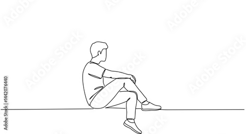 Young man sitting pensively against a minimalist background  