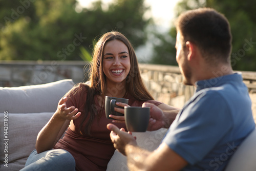 Happy woman talking with a friend drinking in a terrace