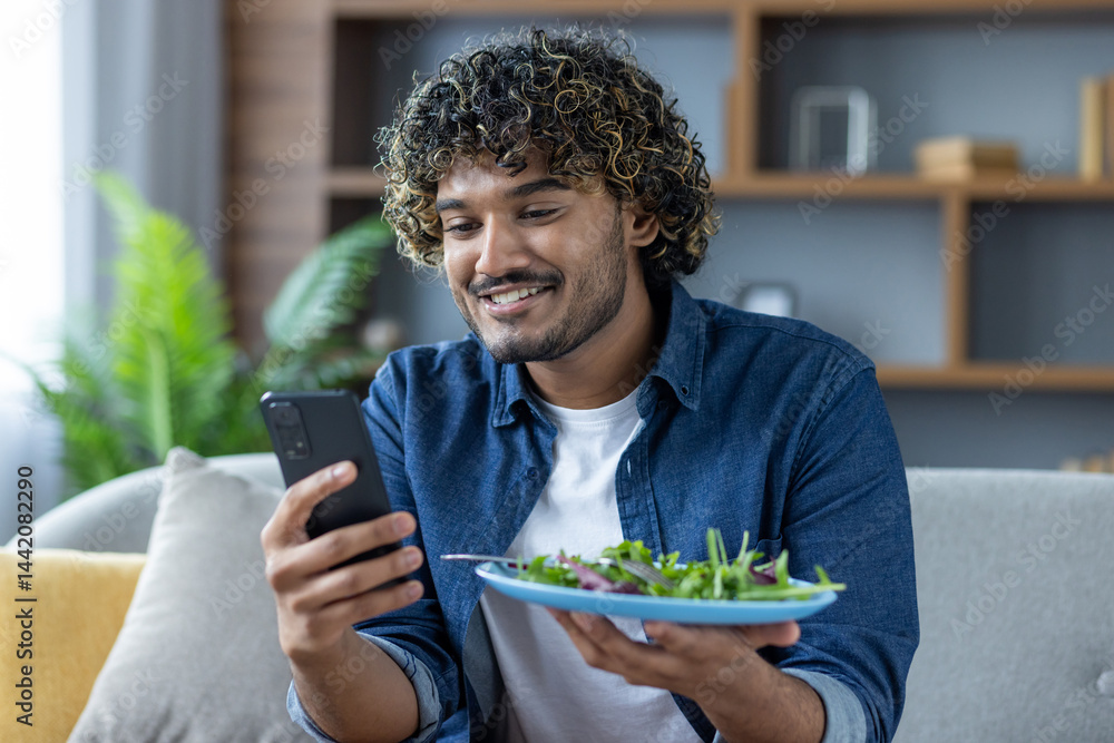 A man uses a phone app to determine the calorie content of his salad. He smiles while analyzing the food