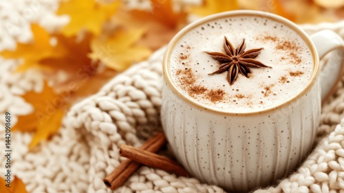 Obraz na płótnie Autumn Spice Latte: A warm and inviting autumn spice latte, garnished with a star anise, sits nestled in a cozy knit scarf, surrounded by fallen autumn leaves. w salonie