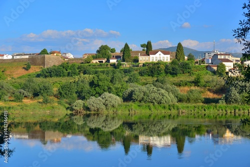 Landscape of the Rio Mino, natural border between Portugal and Spain, with buildings of Moncao reflected in the water