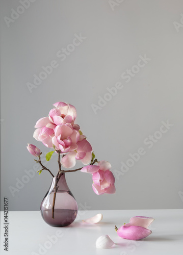 magnolia wreath in glass vase on wall background