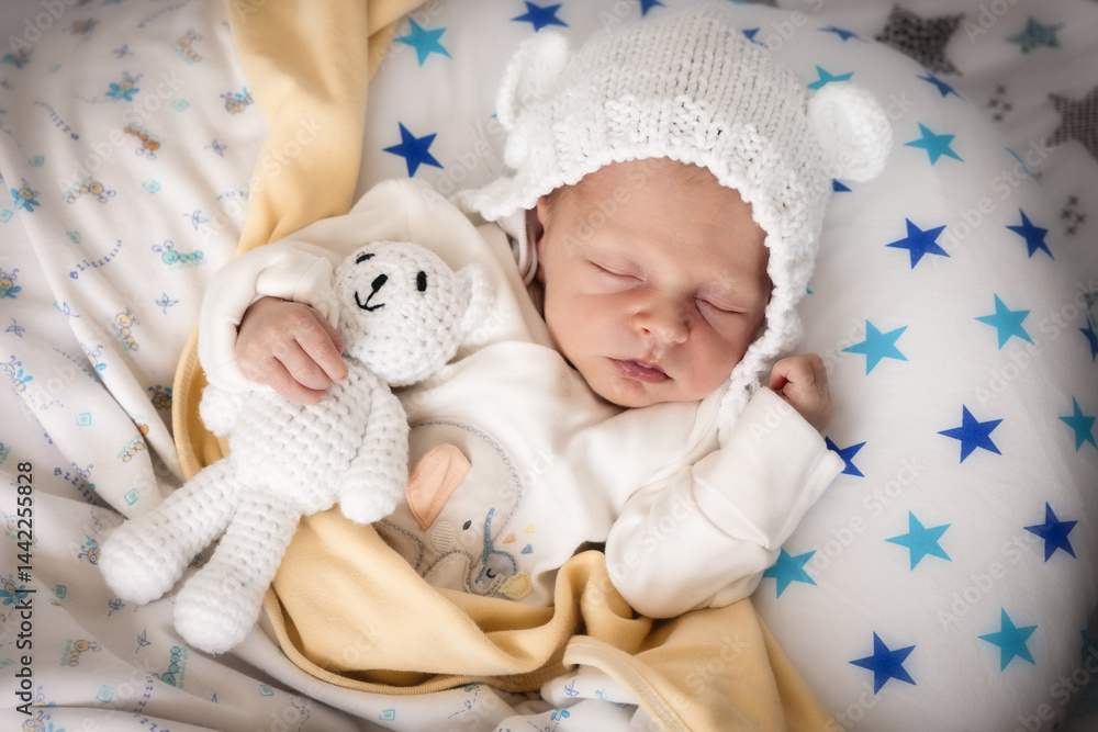 A cute, sleeping 7 days old newborn baby boy with a cuddle toy